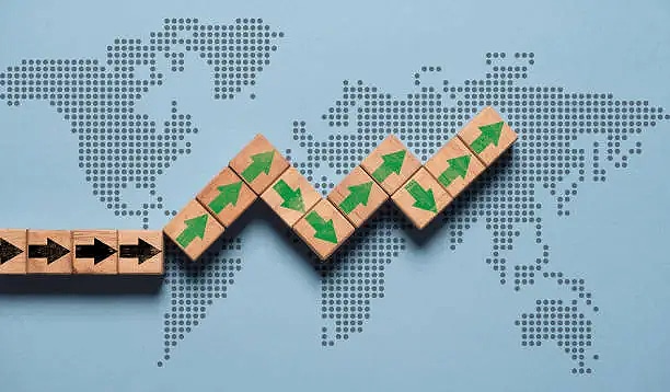 Green up arrow print screen on wooden block cube with world map for global economic growth concept